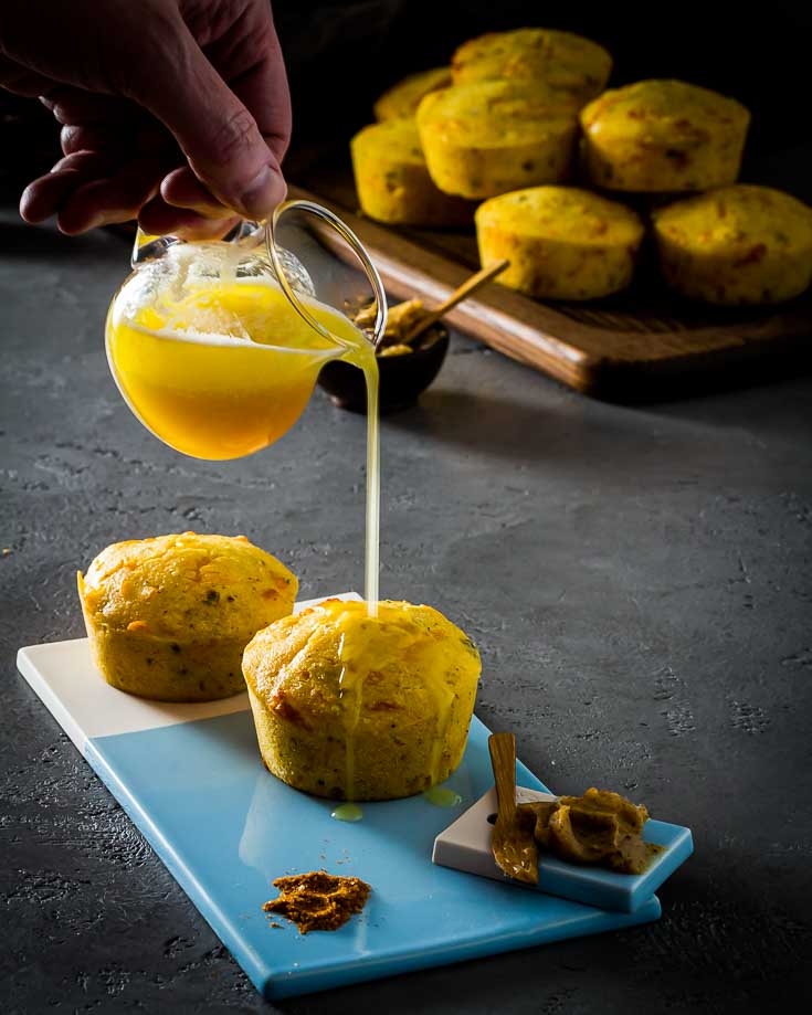 pouring honey glaze on Jalapeno Cheddar Cornbread muffins