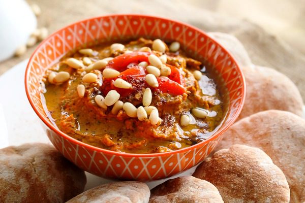 Closeup shot of Roasted Red Pepper Hummus in an orange Moroccan bowl