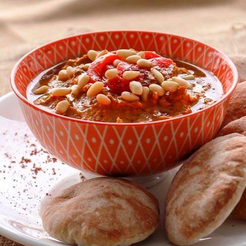 Closeup shot of Roasted Red Pepper Hummus in an orange Moroccan bowl