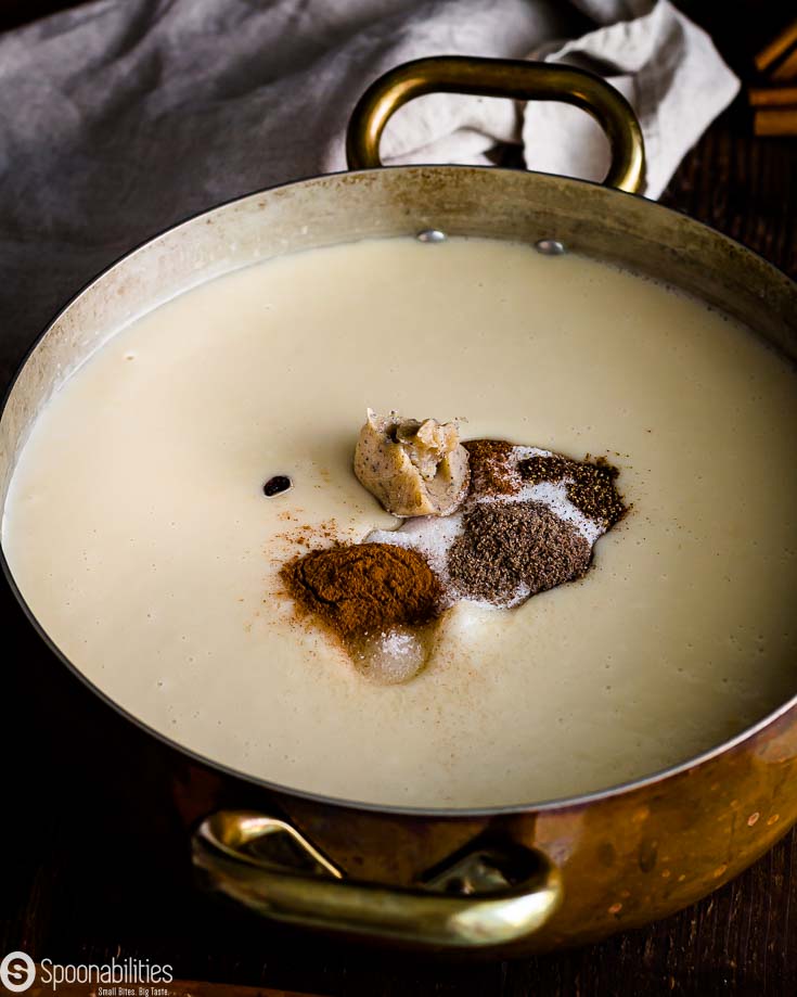 White sweet potato and milk mixture in the pot with ground cinnamon, cloves, nutmeg, cardamon, sugar, raisins & brown butter. Recipe at Spoonabilities.com