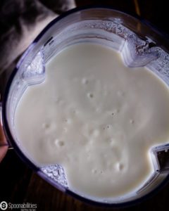 Blender jar with White sweet potato & milk mixture blended. Spoonabilities.com