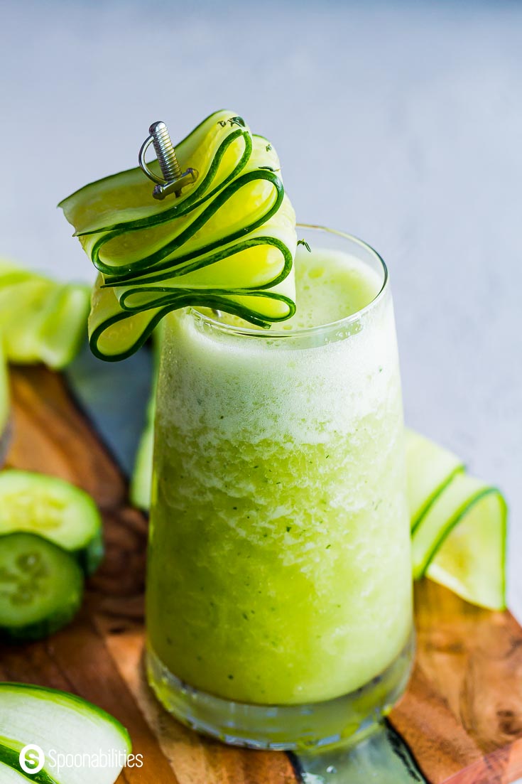 Close up of a margarita slush garnished with cucumbers. 