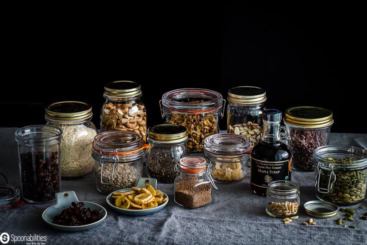 Pantry ingredients ready to be made into an easy grain-free granola with nuts, seeds, spices, dried fruits, maple syrup & olive oil. Available at Spoonabilities.com