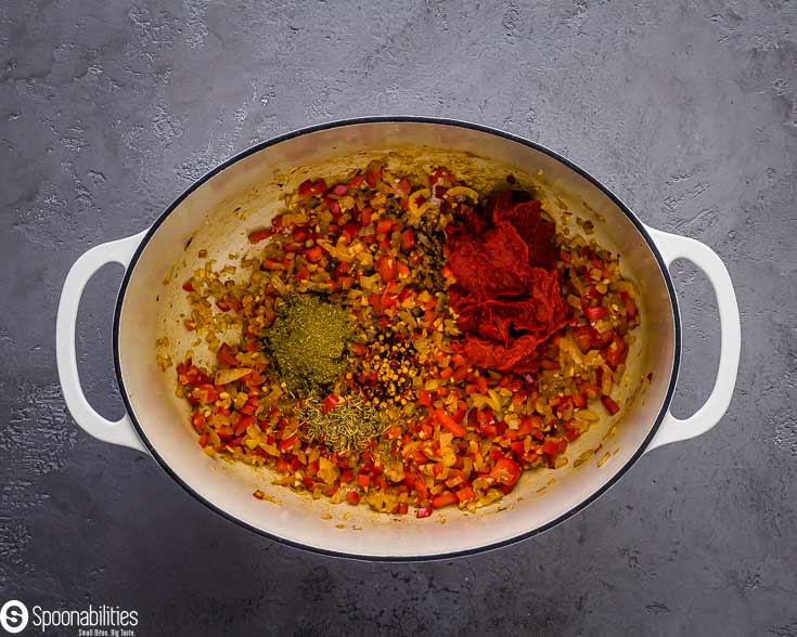 A large cast-iron pot sauteing veggies and spices. Recipe at Spoonabilities.com