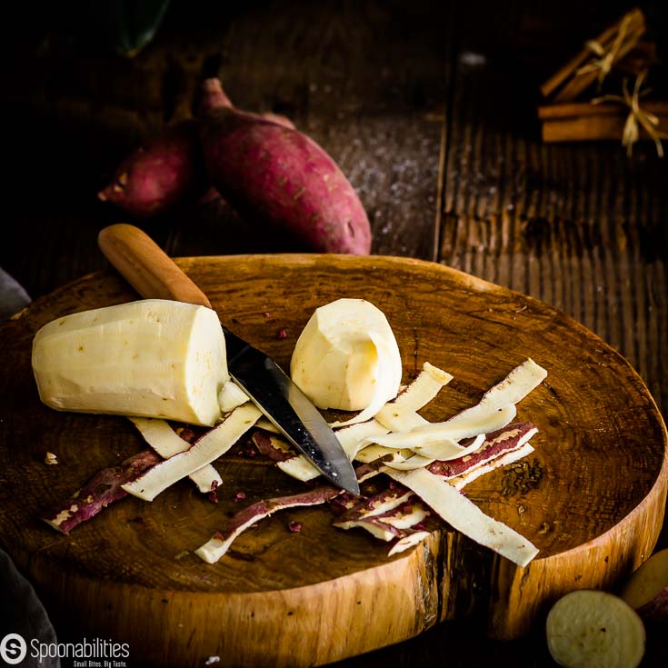 Batata in a wooden cutting board getting peel and cut. Spoonabilities.com