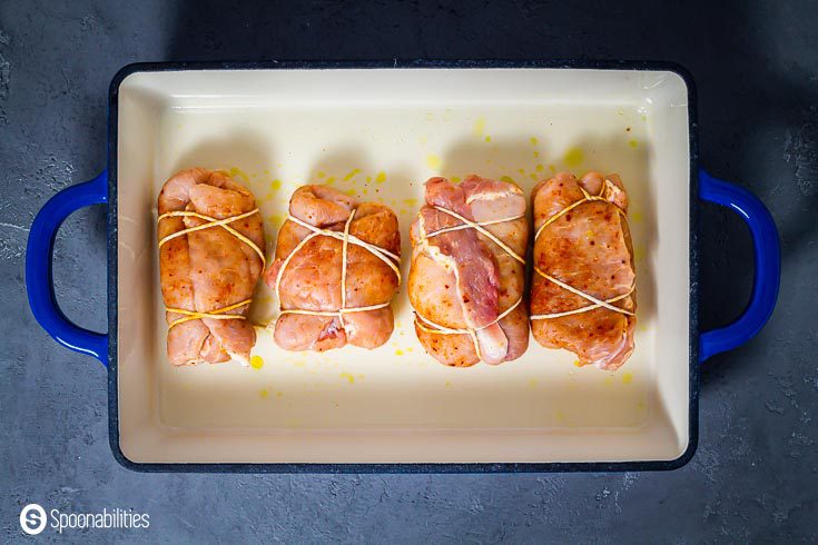 The four stuffed pork with fig salami, hazelnut, Stilton blue cheese & chives in a baking dish. Recipe at Spoonabilities.com