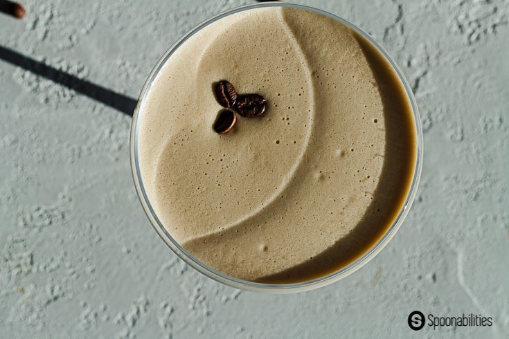 Overhead closeup of 3 coffee beans sitting on a bed of foam in an Espresso Martini