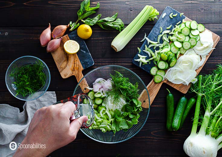 The slaw ingredients in a glass bowl and adding the lemon juice. Recipe at Spoonabilities.com