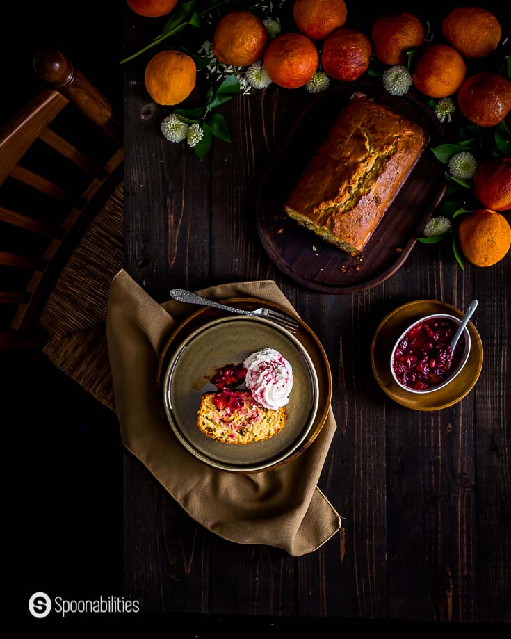 Blood orange cake served with blood orange compote in a dark wooden table with a beautiful set up with fresh fruits. More details at Spoonabilities.com