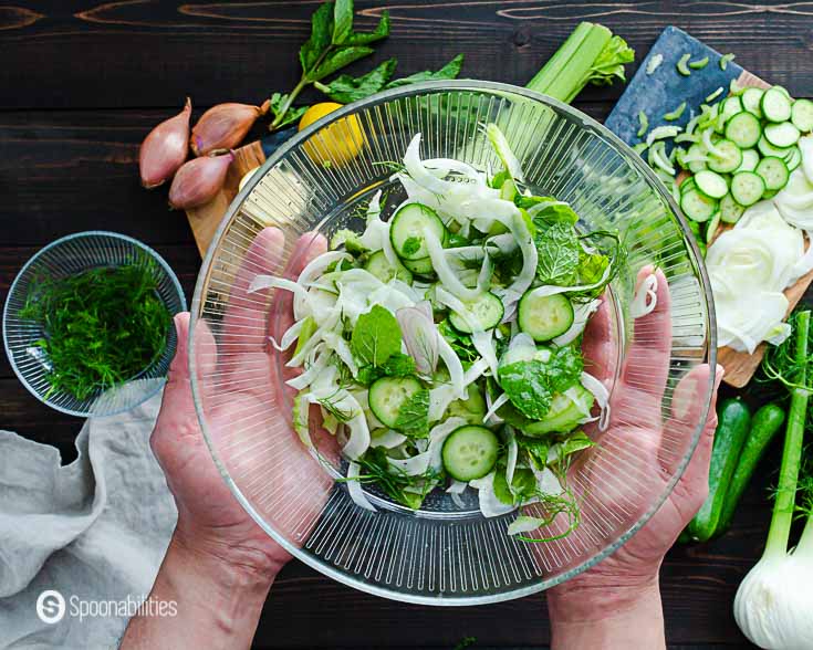 The fennel, cucumber & celery slaw ready to serve in a large glass bowl. Recipe at Spoonabilities.com
