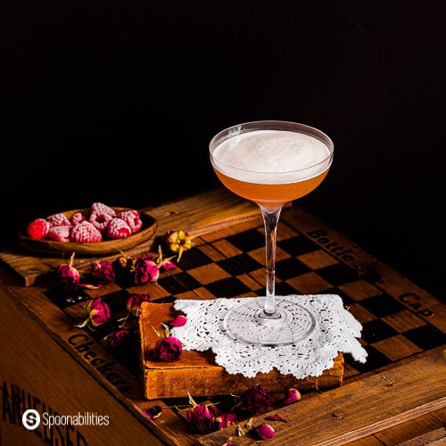 French martini on a white doily with frosted fresh raspberries