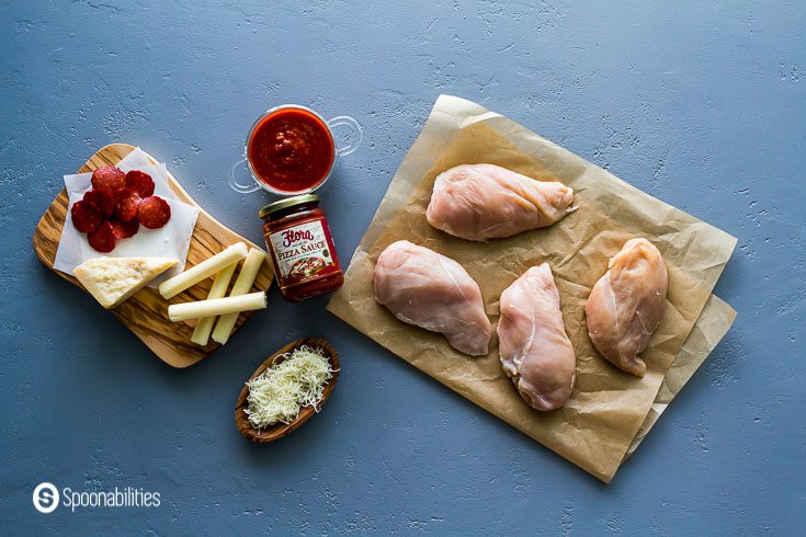 Ingredients for the Chicken recipe like pizza sauce, mozzarella cheese, pepperoni and raw chicken. Recipe at Spoonabilities.com