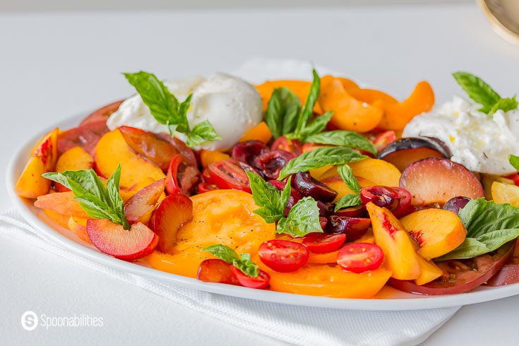 Close up of the Stone Fruit Caprese Salad. Garnished with fresh basil. Recipe at Spoonabilities.com