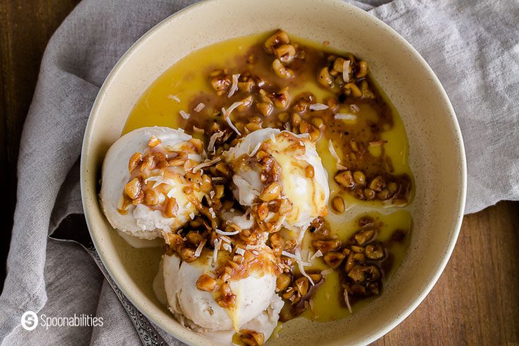 three scoops of coconut ice cream in a round bowl with the Hazelnut Brown Butter Sage Sauce. Recipe at Spoonabilities.com