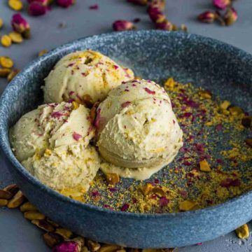 Blue bowl with three scoops of ice cream and garnished with rose petals and pistachio. Recipe at Spoonabilities.com