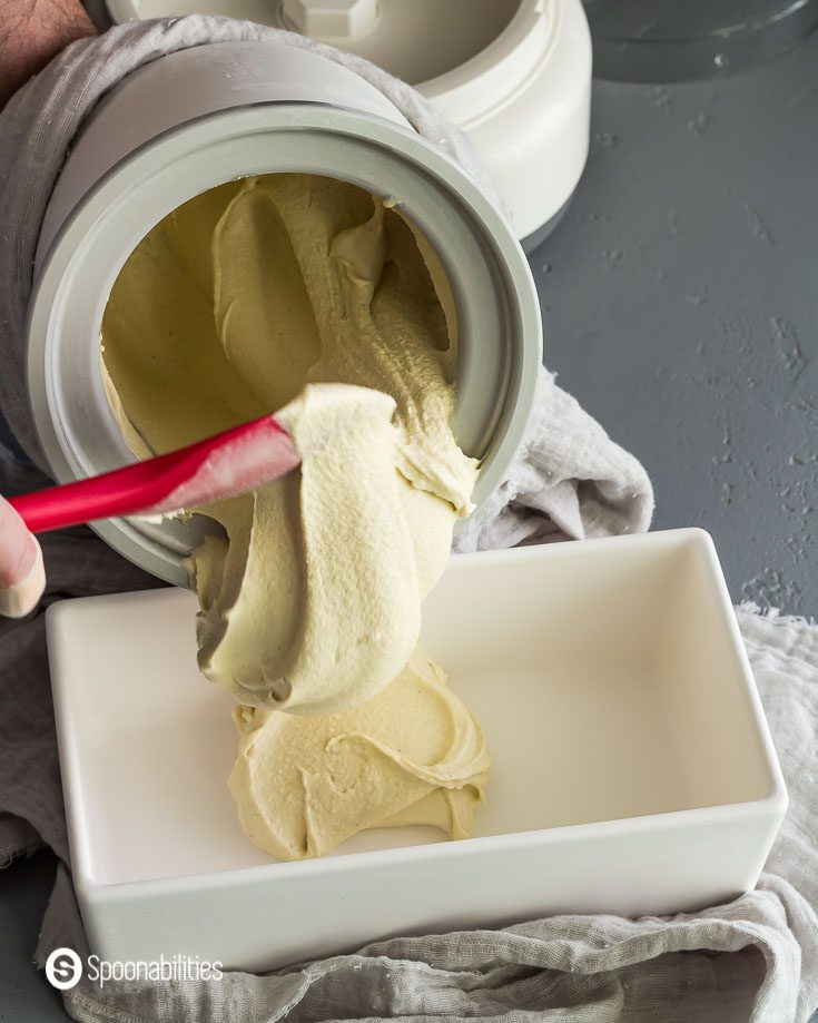 Pouring the Churned ice cream into a white container. Recipe at Spoonabilities.com