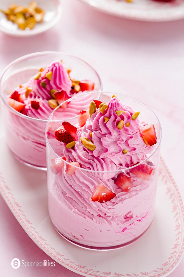 Close up of the strawberry mousse. This no bake dessert is presented in a small glass on top of an antique pink and white plate. Recipe at Spoonabilities.com