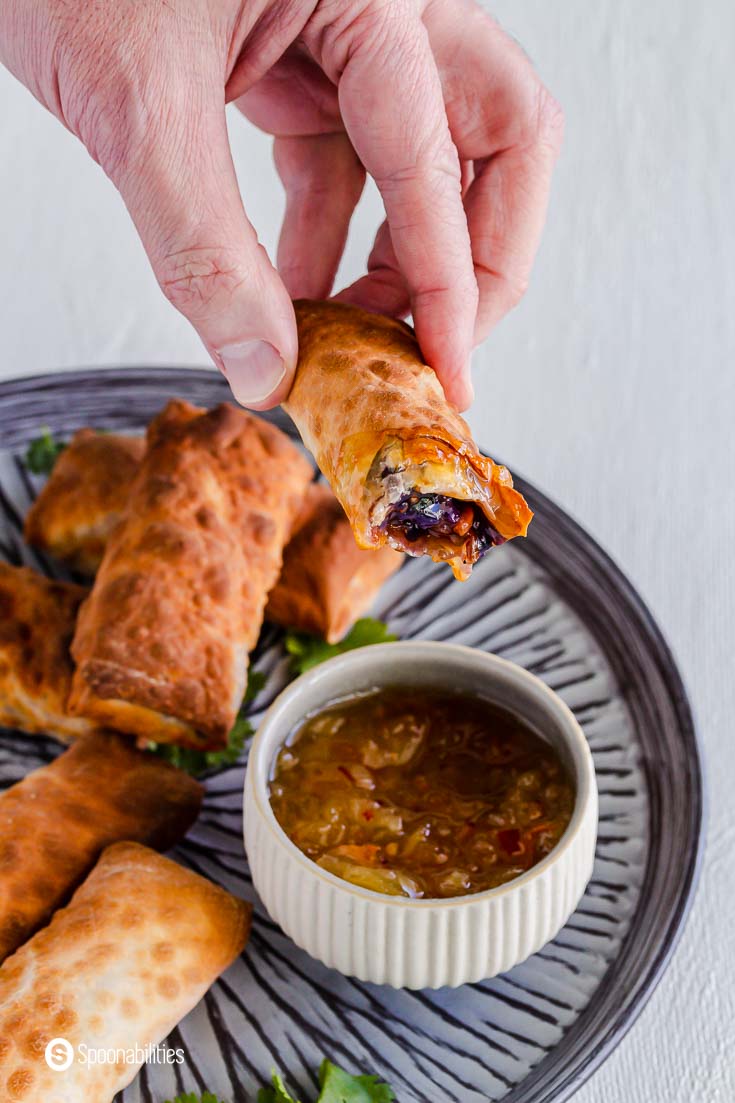 A bite out of the egg roll after dipping it in a pineapple habanero sauce. Recipe at Spoonabilities.com