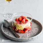 Small sparkle grey plate with a glass bowl on top with fresh strawberries and a foamy sabayon. Recipe at Spoonabilities.com