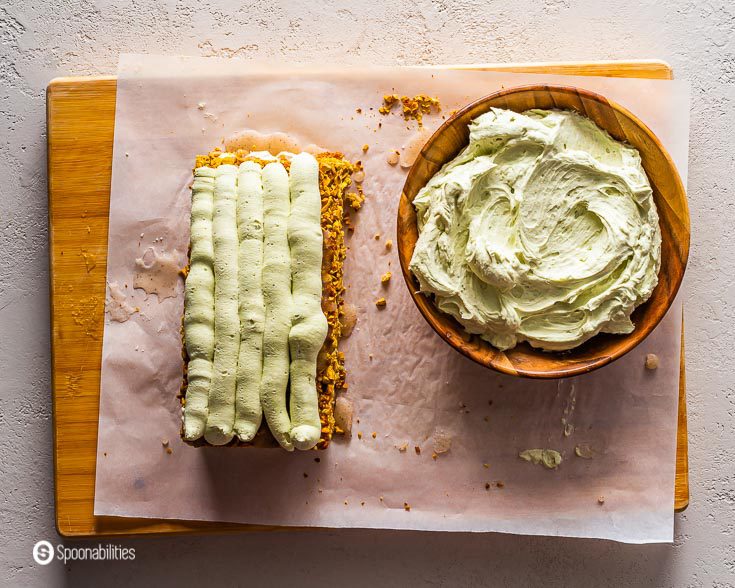 Wooden board and on top the three layers of the cake on top of each other. The last layer has a piped mascarpone cream. Recipe at Spoonabilities.com