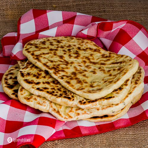Close up photo with Four pieces of Naan bread made at home. Recipe at Spoonabilities.com