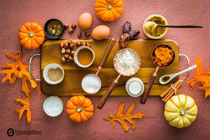 Ingredients separated in small pinch bowls, measuring cups on top of a wooden board with brass handles. Decorated with fall leaves and pumpkins. Recipe at Spoonabilities.com