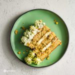 A slice of the pistachio cake on a green plate. This cake is inspired by the Italian traditional dessert Tiramisu and Persian flavors. Recipe at Spoonabilities.com