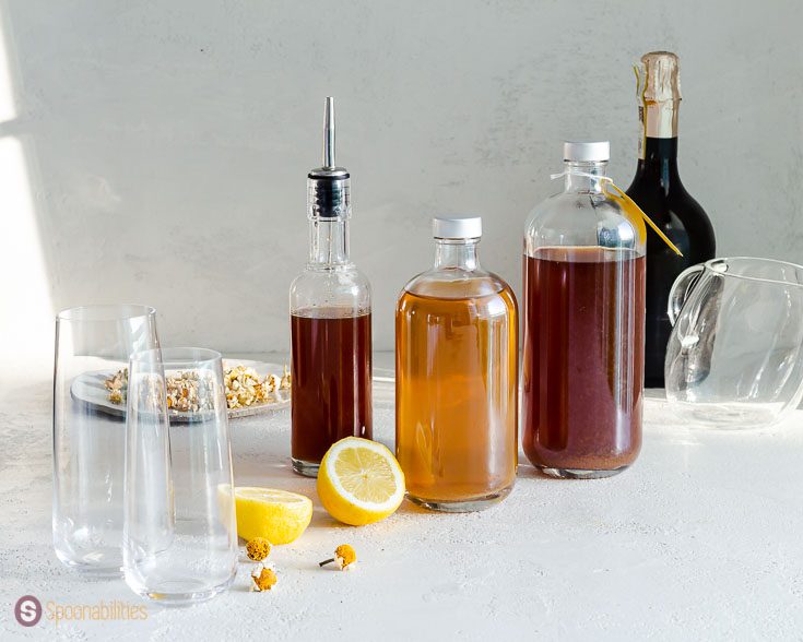 Photo with the ingredients for the punch recipe: Honey syrup, pear infused vodka, chamomile tea, and prosecco. Recipe at Spoonabilities.com