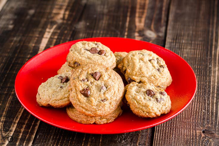 A bunch of Chocolate chip cookies on a red plate. Recipe at Spoonabilities.com