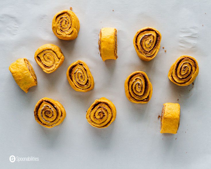 11 pieces of pumpkin cinnamon roll. Using a sharp knife, cut 11-12 pieces. Recipe at Spoonabilities.com