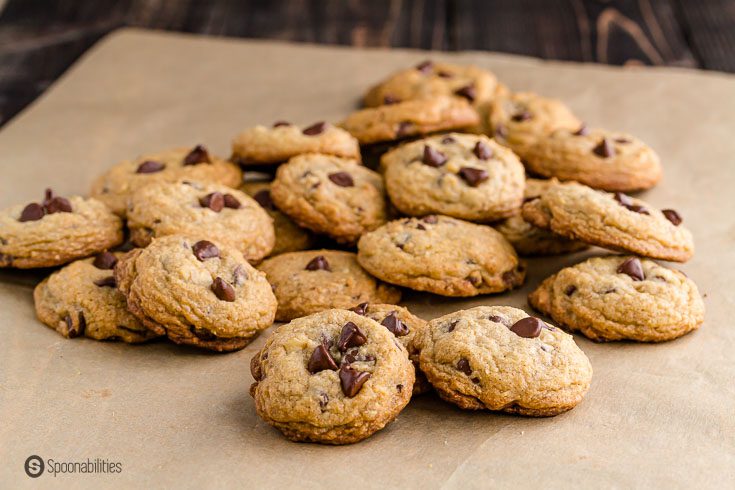 A bunch of chocolate chip cookies on a parchment paper. Recipe at Spoonabilities.com
