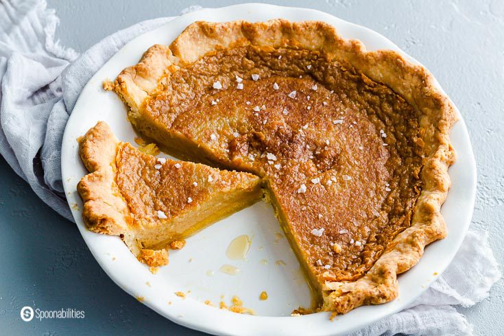 A pie dish with the salted maple pie with a couple of pieces cut out. Recipe at spoonabilities.com