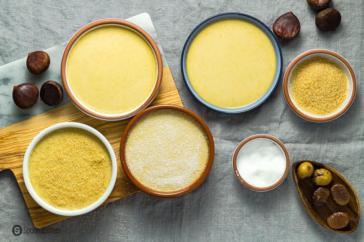 Four Chestnut Burnt cream. One of the ramekins with white sugar and another one with demerara sugar and they are ready to be torched. There are other small bowl with sugar and fresh roasted chestnut. Recipe at Spoonabilities.coms