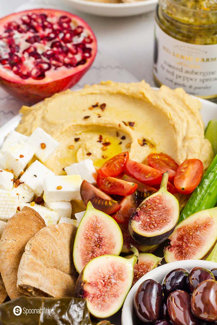 Close up of the platter with fresh figs, cherry tomatoes, pita chips, feta cheese, and hummus. A fantastic Mediterranean food spread. Recipe at Spoonabilities.com