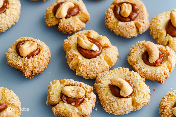 A Close up photo of the cashew cookies filled with Cajeta caramel sauce and a whole cashew on top. Recipe at Spoonabilities.com