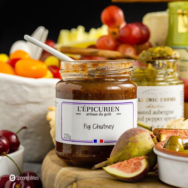 Close-up view of the fig chutney from L'Epicurien with a slice and whole fresh fig in front.