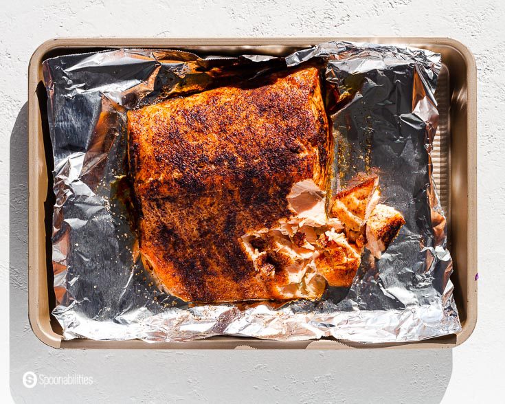 Baking tray with tin foil and a cooked air fryer salmon fillet. Recipe at Spoonabilities.com
