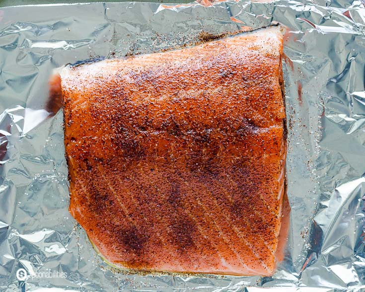 A raw salmon fillet in a baking tray, the salmon is seasoned with sea salt and chipotle pepper powder. Recipe at Spoonabilities.com