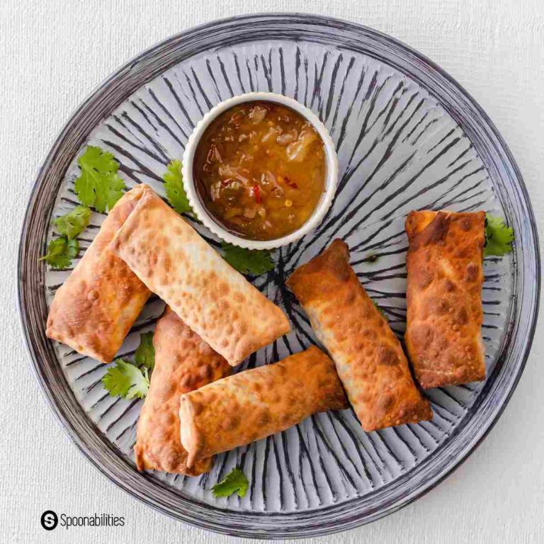 Round plate with some egg rolls and a dipping sauce in a bowl. Recipe at Spoonabilities.com