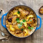 A blue cast iron casserole with the classic recipe chicken and rice casserole with Roasted pineapple habanero sauce. Recipe at Spoonabilities.com