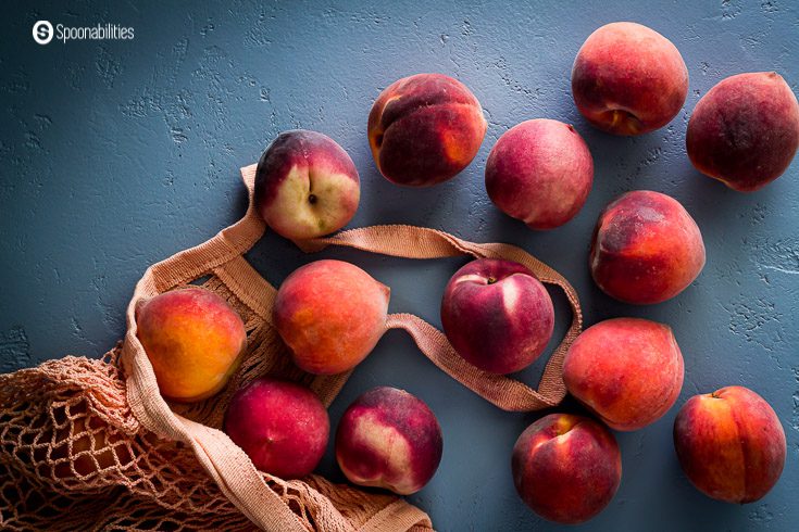 A bag with fresh peaches on a table. Spoonabilities.com