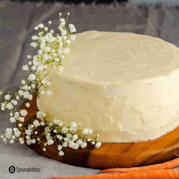 homemade carrot cake on a wooden plate. Learn more about this cake recipe at Spoonabilities.com