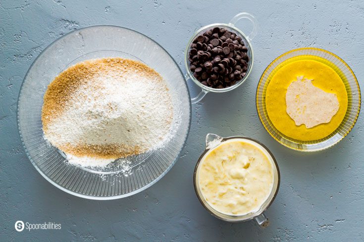 The photo has different bowls with the ingredients to make the Banana chocolate chip muffins with sourdough. Recipe at Spoonabilities.com