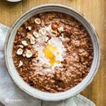 tight close-up of chocolate oatmeal with hazelnut and honey topping