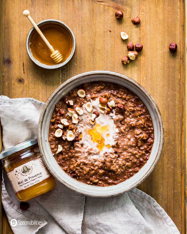 Bowl of cocoa oatmeal next to jar of L'Abeille Provence Flowers Honey