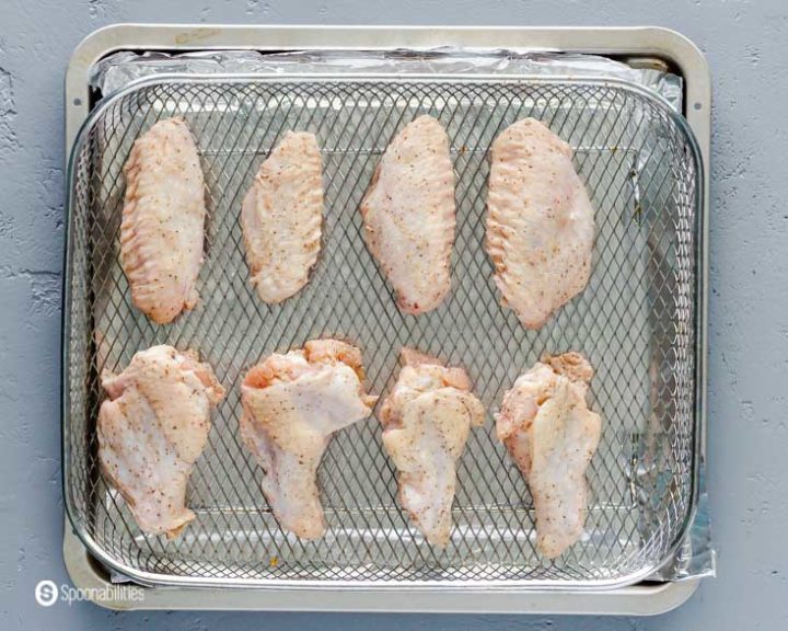 raw seasoned chicken wings in wire basket ready for the air fryer