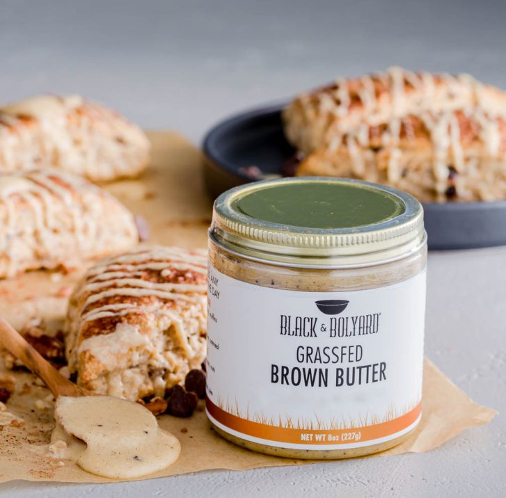 A jar of the original Black & Bolyard brown butter and behind the jar a couple of sourdough scones. Recipe at Spoonabilities.com