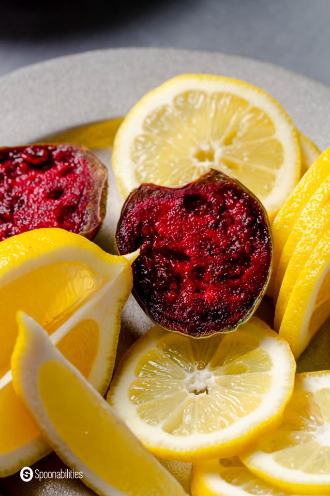 A photo with lemons in slices, wedges and a prickly pear cactus fruit cut in a half.