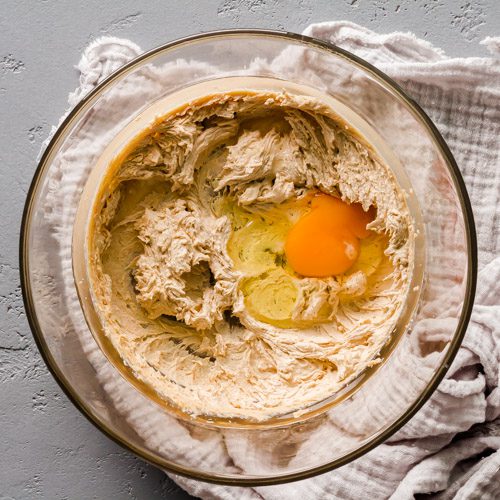 Adding eggs to the cream butter-sugar mix.