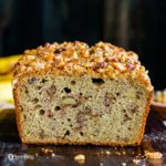 A close up photo of the sourdough banana bread Recipe. You can see the the crumb with pieces of nuts. Recipe at Spoonabilities.com